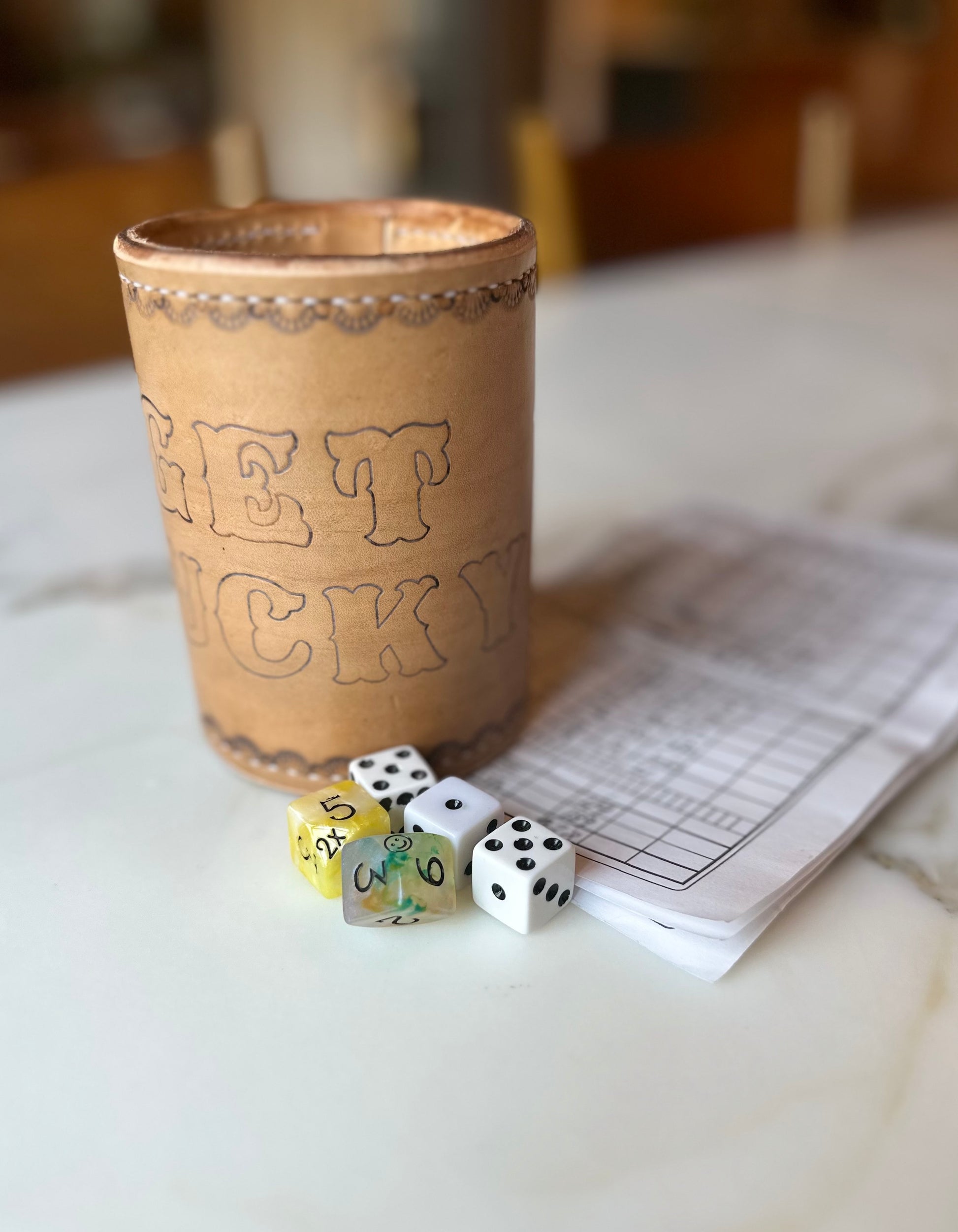 handmade leather dice cup "get lucky" with a yahtzee set up